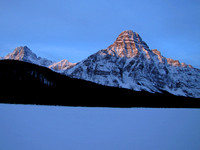 Mount Chephren dominates this view above the snow covered Waterfowl Lakes with Howse Peak in behind to the left.